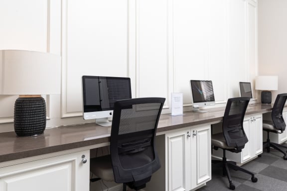 a row of computers sitting on top of a wooden desk at Missions at Chino Hills, Chino Hills